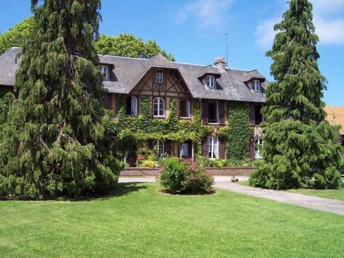 une grande maison avec des arbres dans la cour dans l'établissement LES CHAMPS RABATS, à Villers-sur-Mer