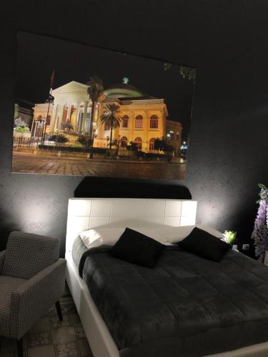 a bedroom with a bed with a picture of a building at ALBA DEL CAPO in Palermo