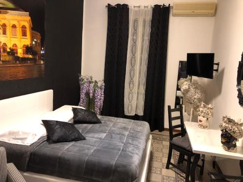 a bedroom with a bed and a table and a desk at ALBA DEL CAPO in Palermo