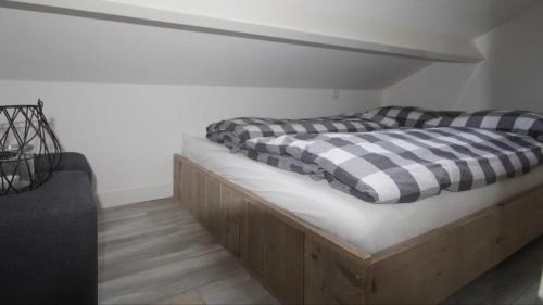 una cama con almohadas a cuadros encima en Lodge, en Noordwijk