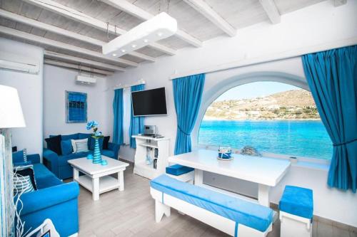 オルノスにあるLuxury Sea House By Blue Waters Mykonosのリビングルーム(青い家具、大きな窓付)