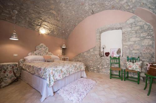 a bedroom with a bed and a stone wall at B&B dell'Osteria in SantʼAnatolia di Narco