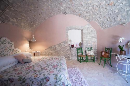 1 dormitorio con 1 cama grande y pared de piedra en B&B dell'Osteria, en SantʼAnatolia di Narco