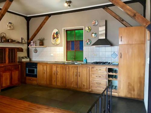 cocina grande con armarios de madera y ventana en Casa porteña en cerro Artilleria, en Valparaíso