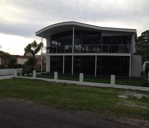 a large building with a fence in front of it at Gull Apartment in Strahan