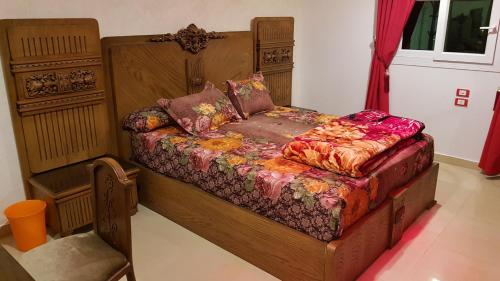 a bedroom with a bed with a wooden frame at Mansoura apartment infront of KFC in Mansoura