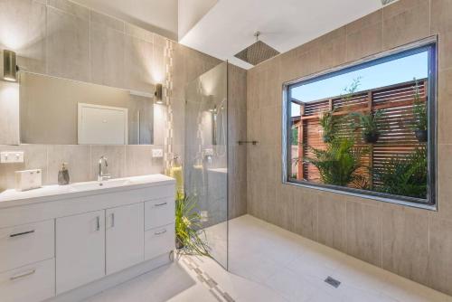 a bathroom with a sink and a shower and a window at 3 WISE MONKEYS, MANSFIELD in Mansfield