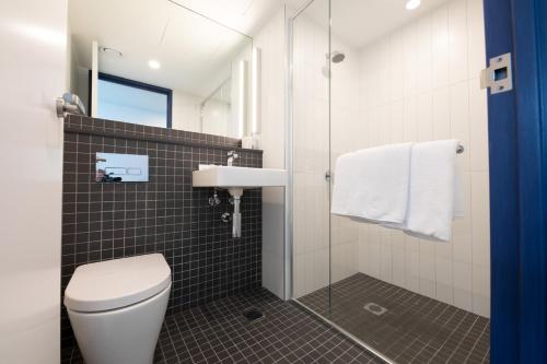 a bathroom with a toilet and a sink and a shower at ibis budget Sydney Airport in Sydney