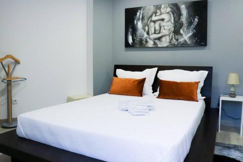 um quarto com uma grande cama branca com almofadas laranja em Casa Nossominho em Vila Nova de Cerveira