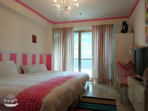 a bedroom with a large bed and a chandelier at CT Theme Suite in Kaohsiung