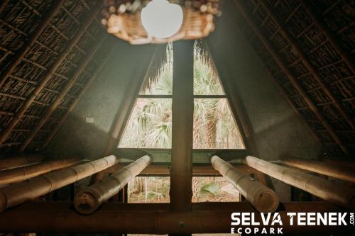 a room with a window and a chandelier at Selva Teenek Eco-Park in Ciudad Valles