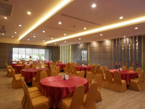 a banquet hall with red tables and chairs at Som-O House Hotel in Nakhon Ratchasima