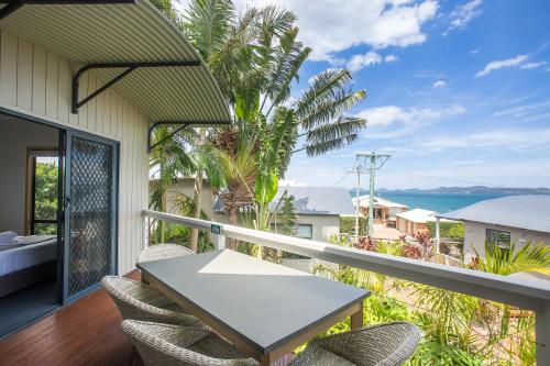 a balcony with a table and chairs and the ocean at Thou Walla Sunset Retreat in Soldiers Point