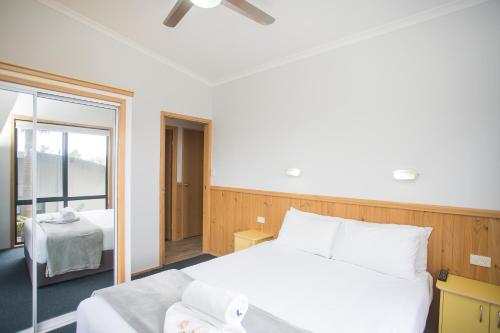 a bedroom with a white bed and a window at Thou Walla Sunset Retreat in Soldiers Point