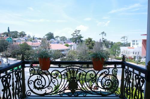 a balcony with two potted plants on a railing at Sammy Dalat Hotel in Da Lat