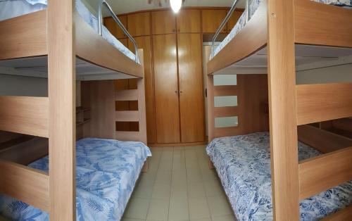 um quarto com 2 beliches e uma cama em Apto Pé na Areia Santos em Santos