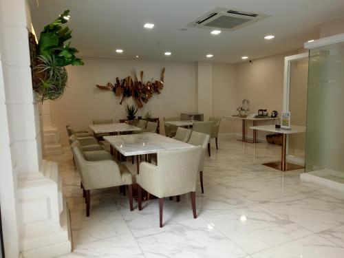 a restaurant with tables and chairs in a room at V Boutique Hotel in Phnom Penh