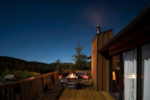 a deck with a table and chairs at night at 'Love' Hanmer Couples Retreat Limited in Hanmer Springs