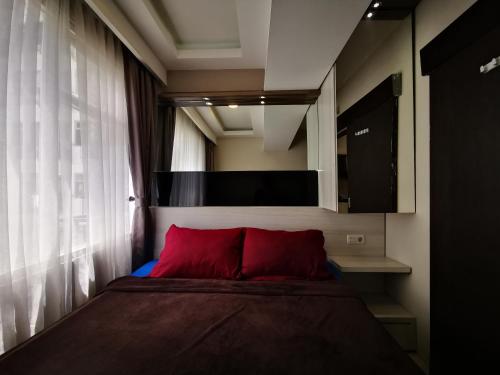 a bedroom with a bed with a red pillow at Raja Apartemen Jarrdin Type 33 in Bandung