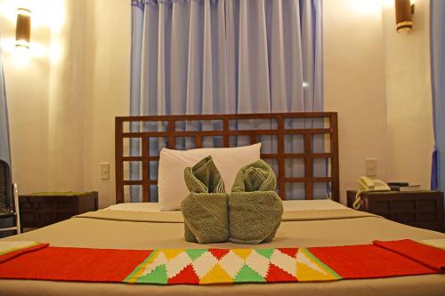 a bedroom with a bed with two pillows on it at Coron Hilltop View Resort in Coron