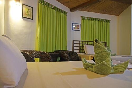 a green curtain in a room with a table at Coron Hilltop View Resort in Coron