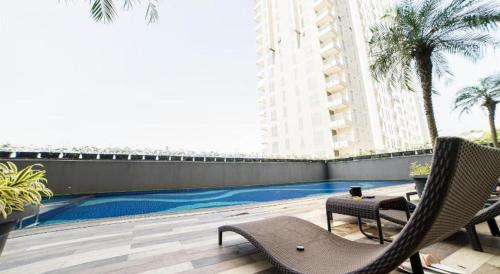 a balcony with chairs and a swimming pool in a building at Bacup Studio Apartment @Galeri Ciumbuleuit in Bandung