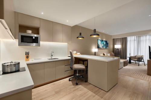 a kitchen and living room with a table and a chair at Hyatt House Chengdu Pebble Walk in Chengdu