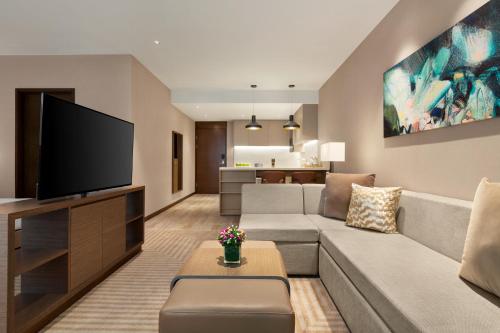 a living room with a couch and a flat screen tv at Hyatt House Chengdu Pebble Walk in Chengdu