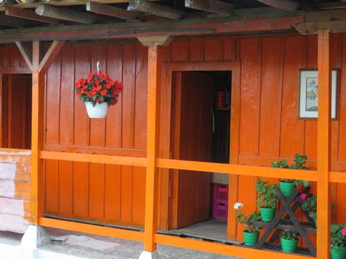 a wooden house with a flower pot on the wall at Reserva La Rivera in Salento
