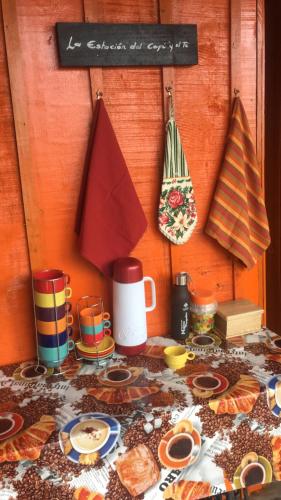 una mesa con platos y tazas y un cartel en la pared en Reserva La Rivera, en Salento