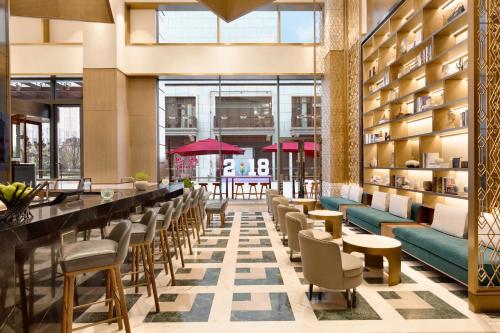 a lobby with a bar and chairs and tables at Hyatt House Chengdu Pebble Walk in Chengdu