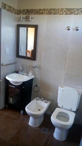 a bathroom with a white toilet and a sink at Cabaña El Tordillo in Potrero de Garay