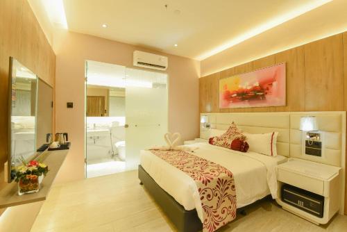 a bedroom with a large bed and a bathroom at Red Hotel Cubao, Quezon City in Manila