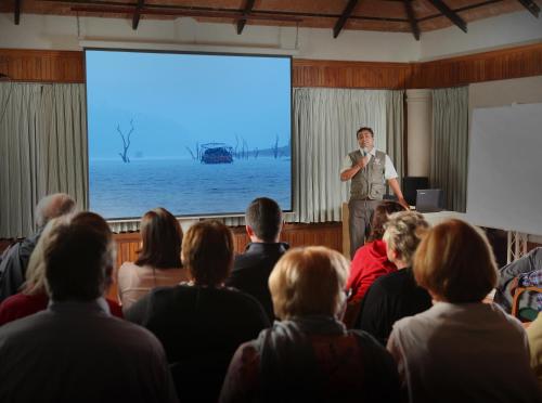 a man standing in front of a screen in front of a crowd at Greenwoods Resort, Thekkady in Thekkady