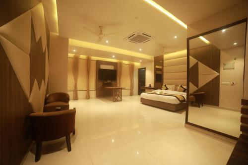 a hotel room with a bed and a mirror at Hotel Le Grande in Jaipur