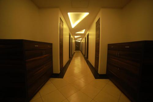 an empty hallway with a hallway with cabinets and a light at Hotel Le Grande in Jaipur