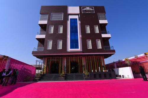 a building on a red carpet with people standing around it at Hotel Le Grande in Jaipur