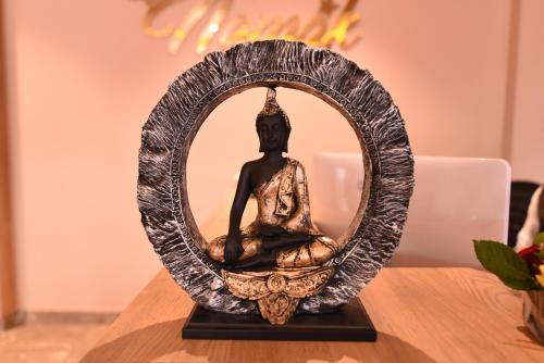 a statue of a buddha in a mirror on a table at Hotel Le Grande in Jaipur