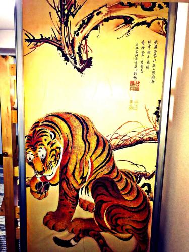 a painting of a tiger on a wall at Casa Viento Stay Inn in Hiroshima