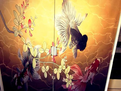 a painting of birds and flowers on a wall at Casa Viento Stay Inn in Hiroshima