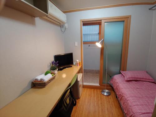 a bedroom with a bed and a desk with a computer at I sleep alone in Seoul