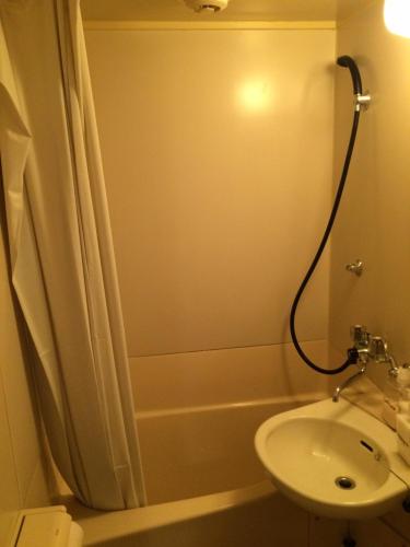 a bathroom with a sink and a tub and a toilet at Casa Viento Stay Inn in Hiroshima