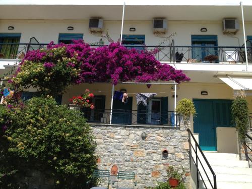 a building with purple flowers on a balcony at Angeliki Beach Hotel in Megali Ammos