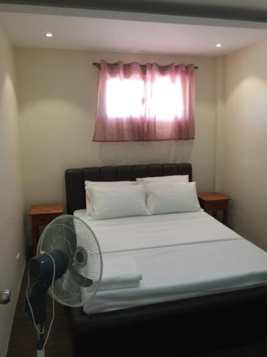 a bedroom with a bed with a fan and a window at Squareville Subdivision in San Fernando