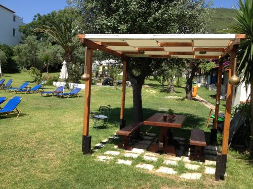 a wooden pavilion with a picnic table and chairs at Angeliki Beach Hotel in Megali Ammos