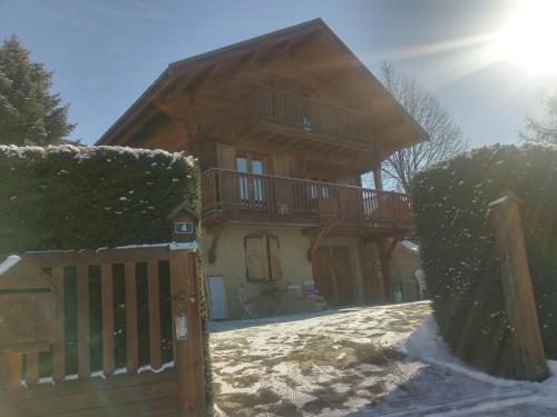 a house with a wooden gate in the snow at La Carline in Guillestre