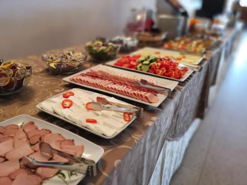 a buffet with meats and vegetables on a table at Monterai Resort in Poiana Brasov