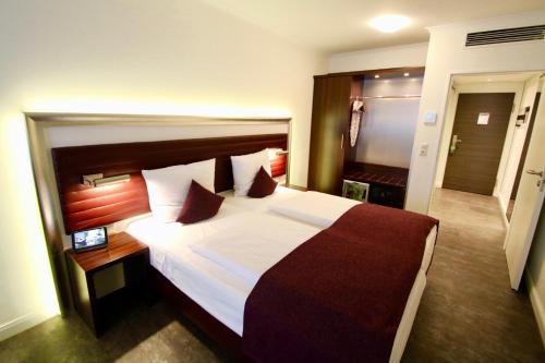 a hotel room with a large bed with white sheets at Hotel Metropol by Maier Privathotels in Munich