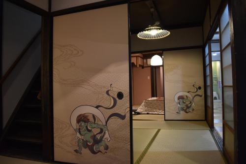 a mirror in a hallway with a room with a bed at Nishioji TANUKI 西大路 狸 in Kyoto