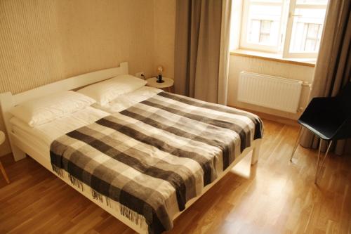 a bedroom with a bed with a checkered blanket at LVIV WALL STREET APT in Lviv
